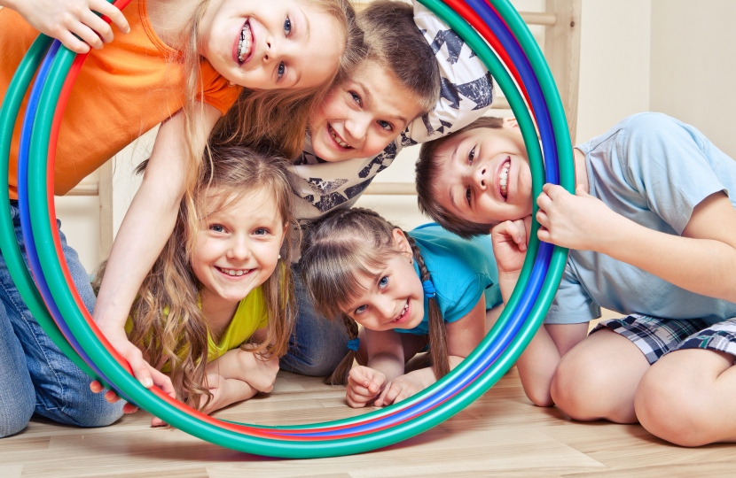 Children smiling through Hula Hoop