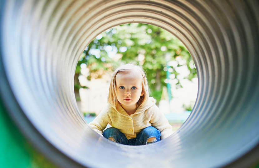 Child looking through play tunnel