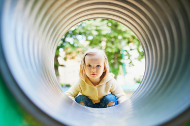 Child looking through play tunnel